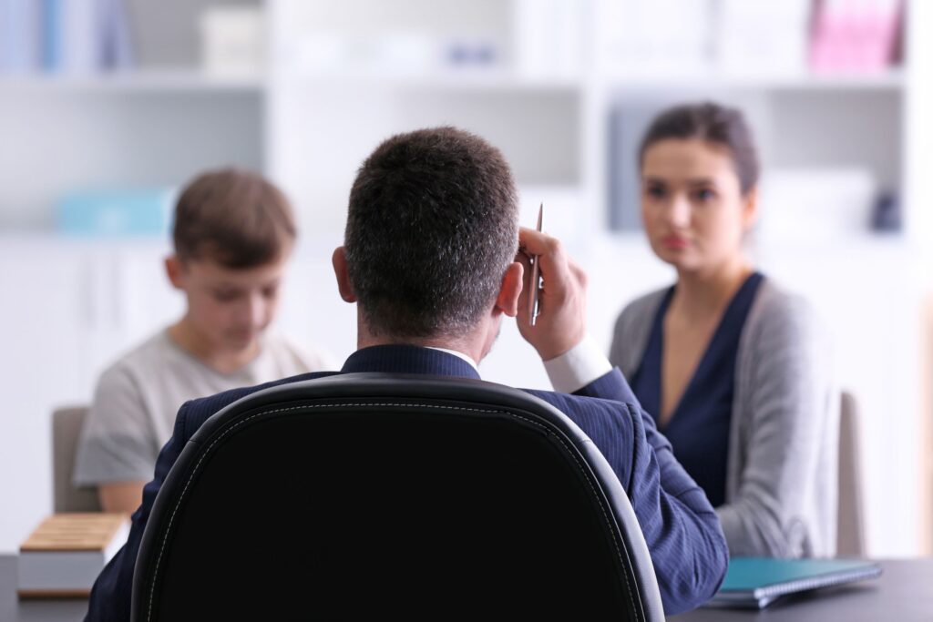 A parent and her son sit in the principal’s office.