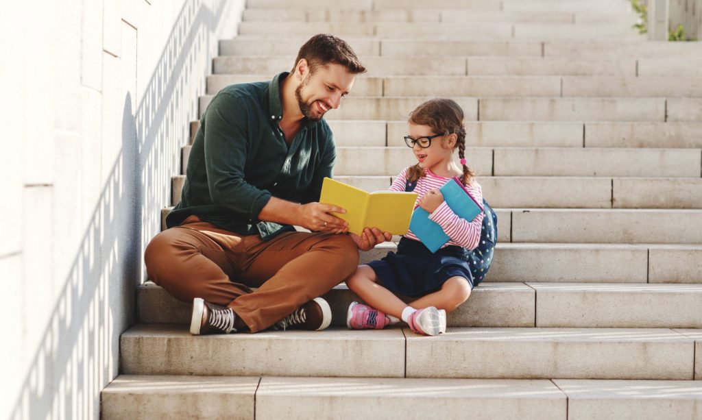 A father reads with his daughter for school.