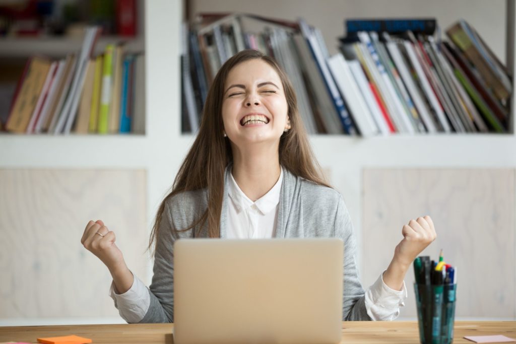 A young female appears happy after receiving good online news.