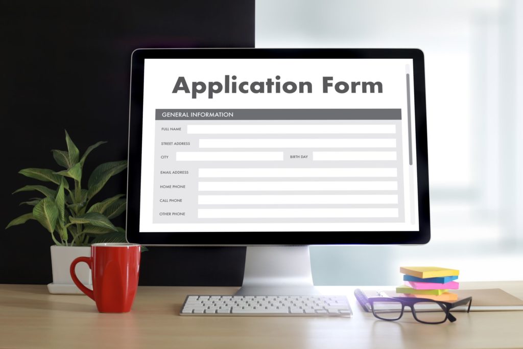 A blank application form is pulled up on an office computer.