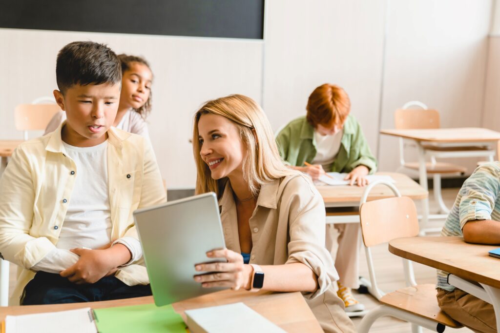 A teacher helps her student one on one at his desk.