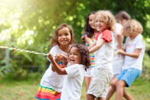 A group of students play Tug of War, participating in field day activities.