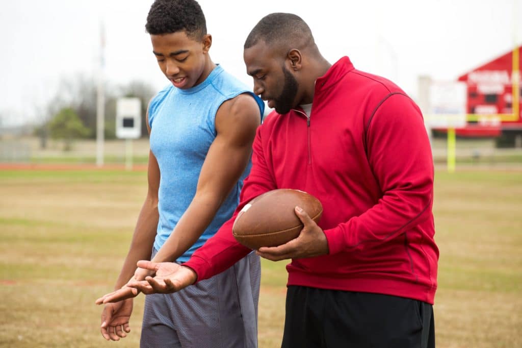 Football coach teaching a player.