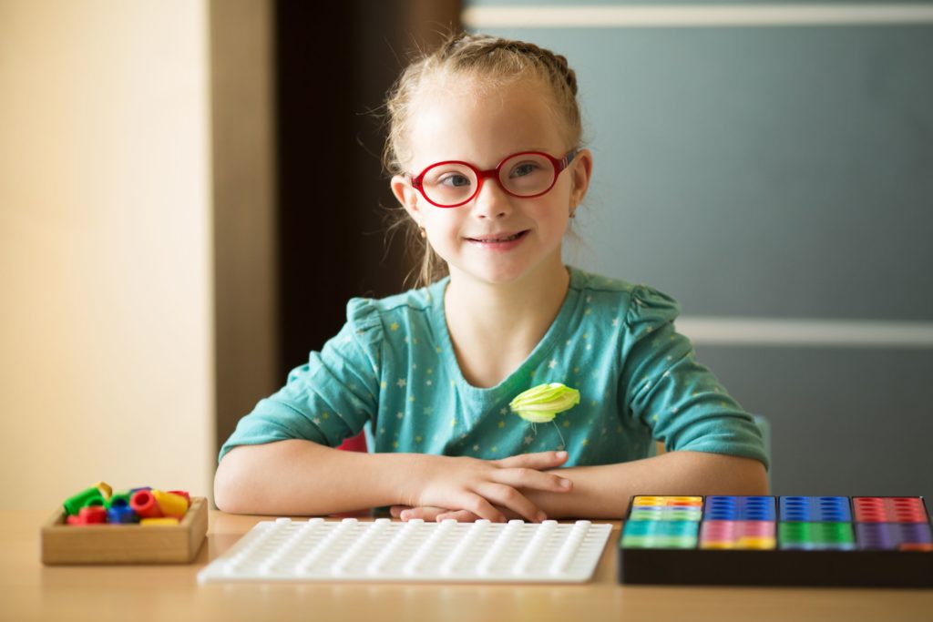 An early childhood special education student sits in a classroom.
